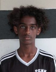 Young male soccer player in black and white uniform posing for a team photo.