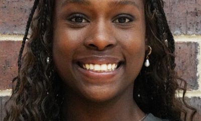 Woman in sports uniform smiling at camera.