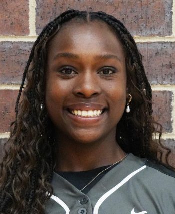Woman in sports uniform smiling at camera.