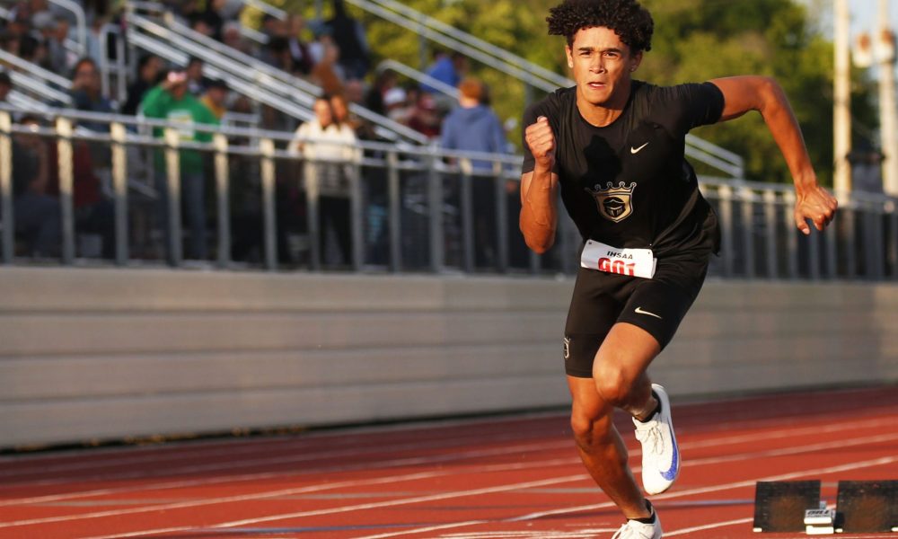 Man in black uniform running on track.