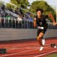 Man in black uniform running on track.