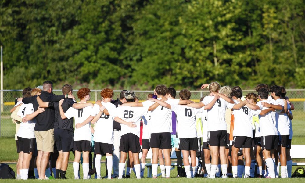 Soccer team celebrates on field.