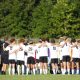 Soccer team celebrates on field.