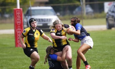Women's rugby team playing on field.