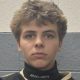 Man in a hockey uniform looking at the camera.