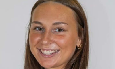 Ally Kois wearing brown volleyball uniform posing for a portrait.