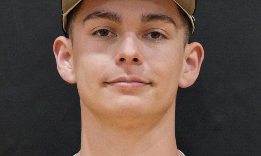 This is a portrait of a young male athlete wearing a baseball uniform, posing for a team photo.
