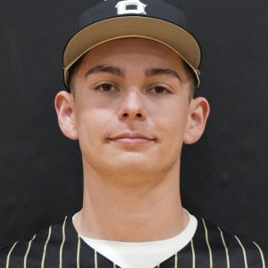 This is a portrait of a young male athlete wearing a baseball uniform, posing for a team photo.