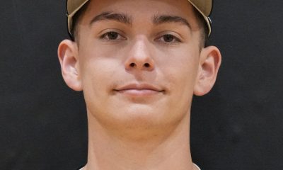 This is a portrait of a young male athlete wearing a baseball uniform, posing for a team photo.