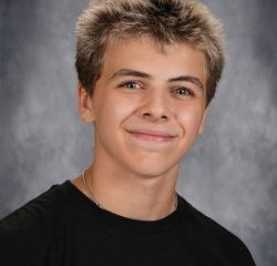 Young man with spiky hair posing for school portrait.