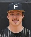 Baseball player posing in a baseball uniform.