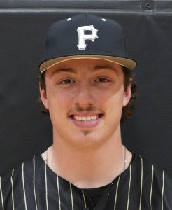 Baseball player posing in a baseball uniform.