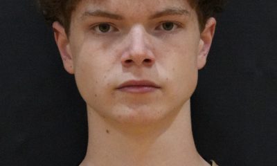 Lacrosse athlete wearing a black uniform with white lettering.