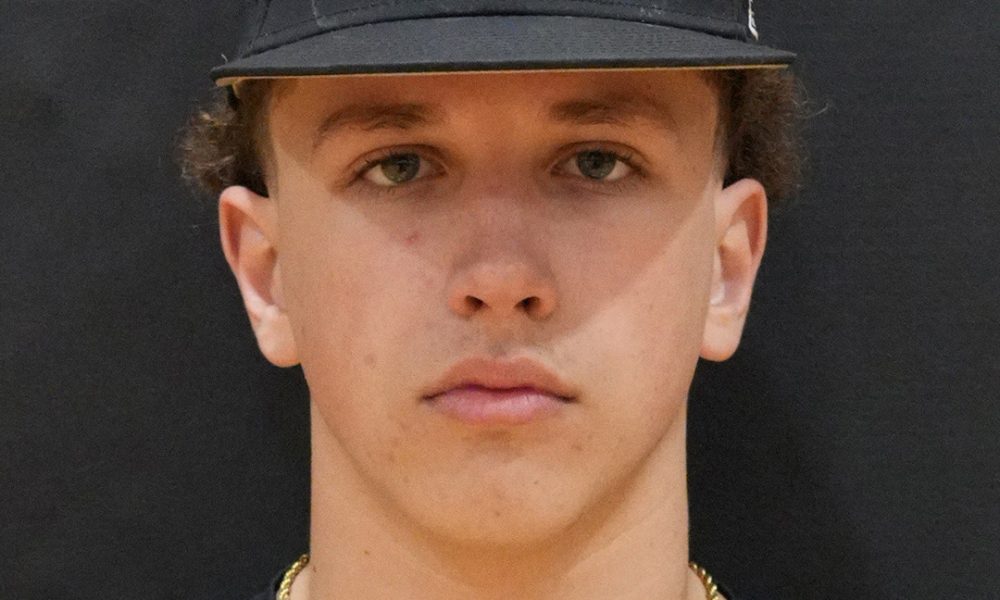 Man in baseball uniform posing for portrait.