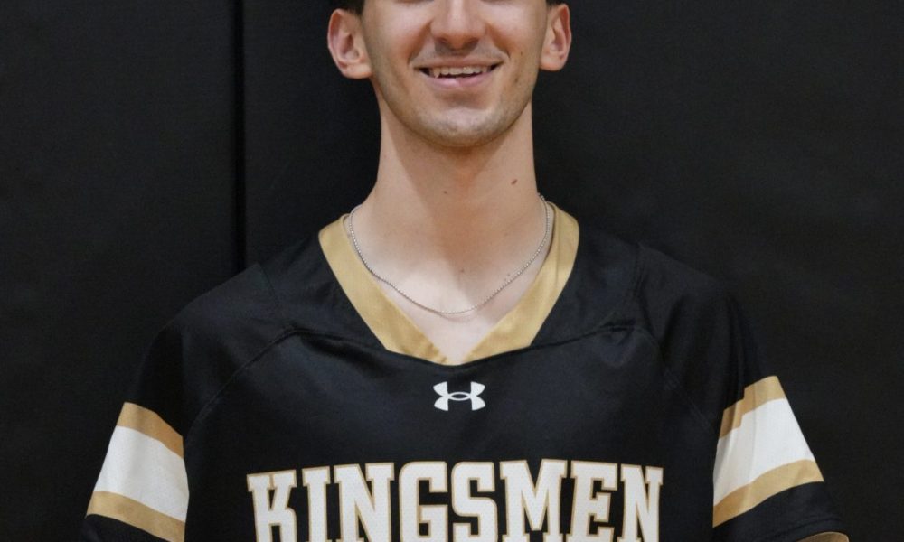 This is a person wearing a black jersey with white lettering and numbers, posed in front of a basketball hoop.