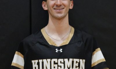 This is a person wearing a black jersey with white lettering and numbers, posed in front of a basketball hoop.