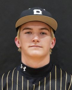 Baseball player posing in uniform for team portrait.