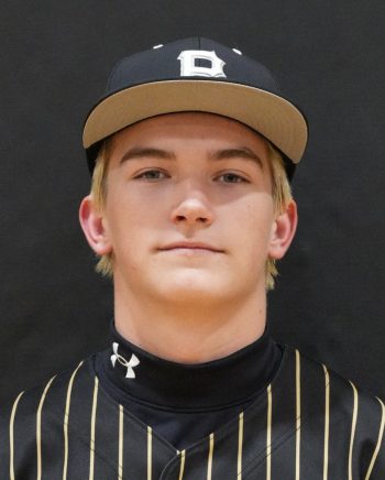 Baseball player posing in uniform for team portrait.