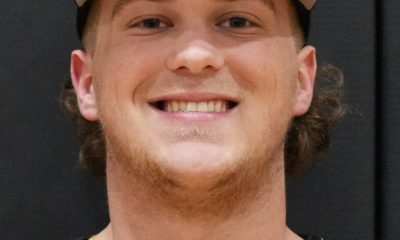 Man in baseball uniform smiling at camera.