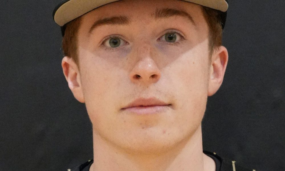 Young man in baseball uniform posing for portrait.