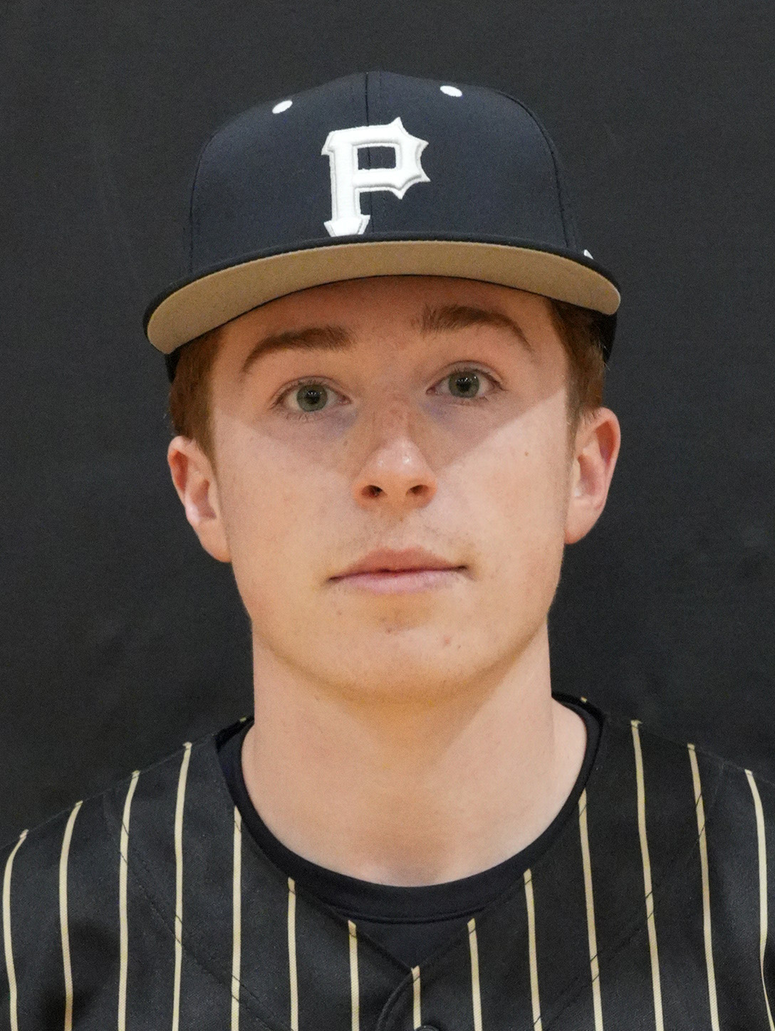 Young man in baseball uniform posing for portrait.