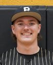 Baseball player in a black and gold uniform smiling at the camera.