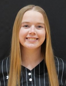 Girl with long blonde hair smiling at camera.