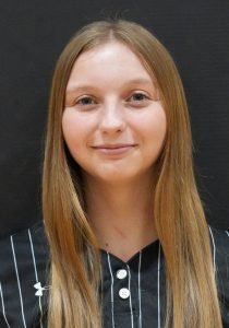 Woman in a black and white striped shirt posing for a portrait.