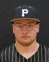 Man wearing glasses, black baseball cap with white lettering, and sports jersey.