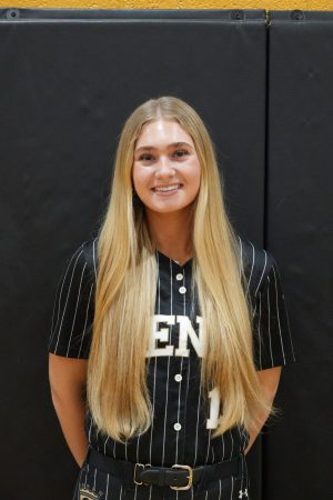 Woman in a black baseball uniform posing for a photo.