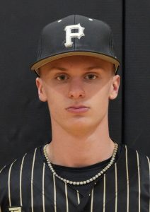 Baseball player in a black and gold uniform posing for a portrait.
