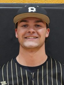 Man in baseball uniform smiling at camera.