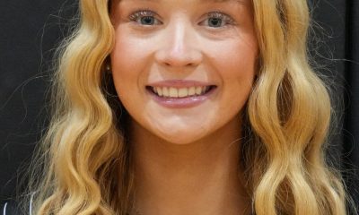 Woman with long blonde hair smiling at camera.