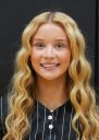 Woman with long blonde hair smiling at camera.