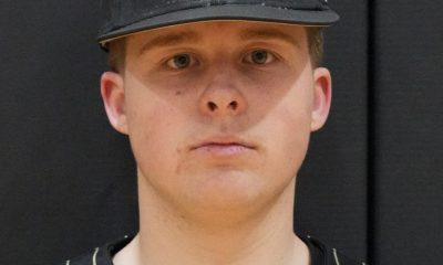 Baseball player in uniform posing for team portrait.