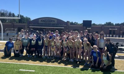 Girls Track Team poses with a trophy.