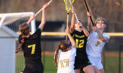 Girl's lacrosse team celebrates victory on field.
