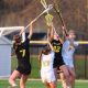 Girl's lacrosse team celebrates victory on field.