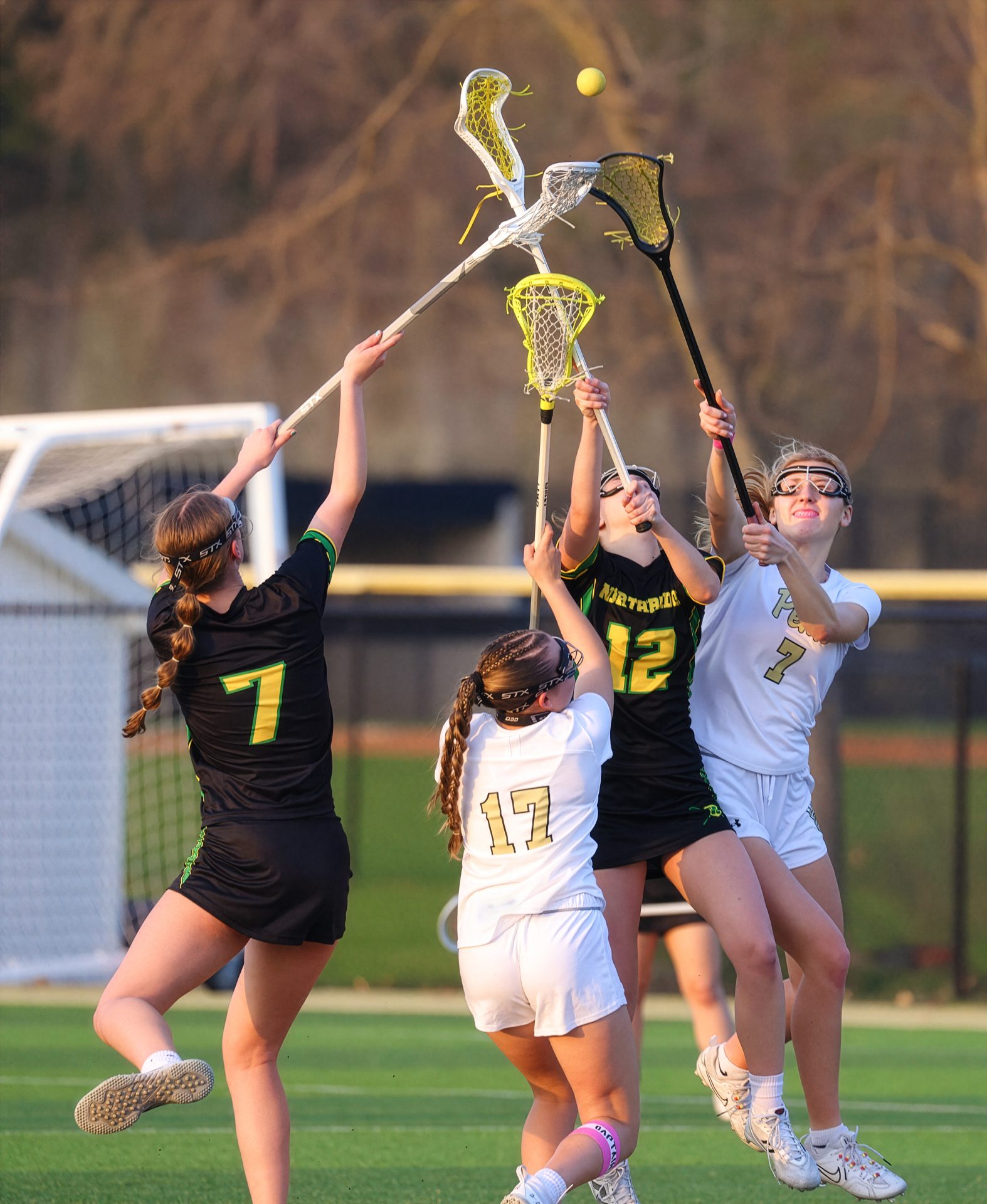 Girl's lacrosse team celebrates victory on field.