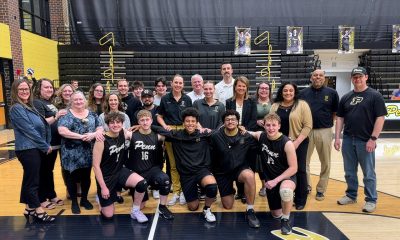Team of basketball players posing for a picture after a game.