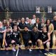 Team of basketball players posing for a picture after a game.