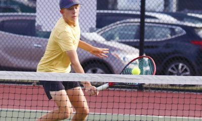 A tennis player hits a tennis ball on a court.