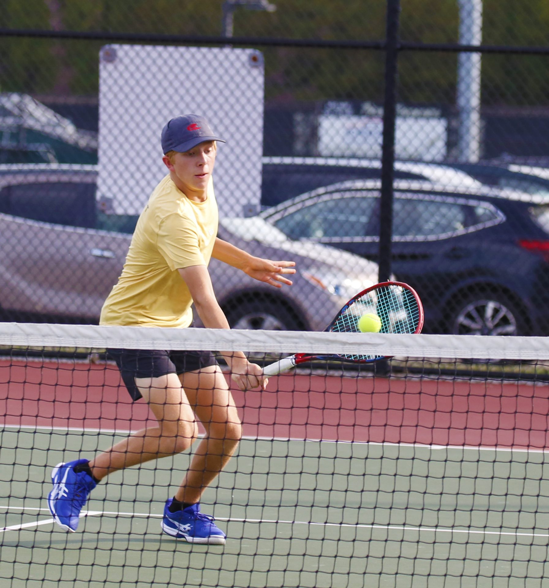 A tennis player hits a tennis ball on a court.