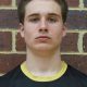 Young male athlete posing for a portrait, looking directly at the camera with a neutral expression.