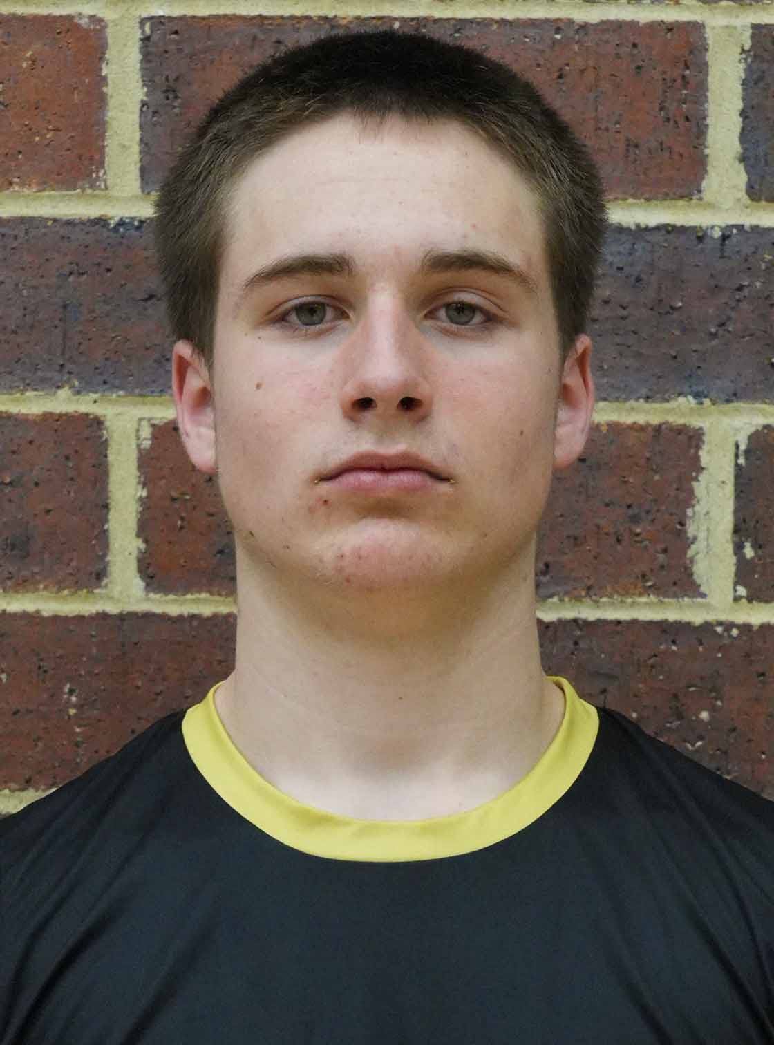 Young male athlete posing for a portrait, looking directly at the camera with a neutral expression.