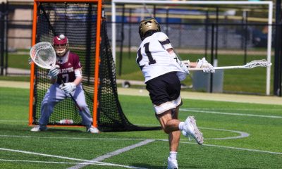 Man playing lacrosse on field.
