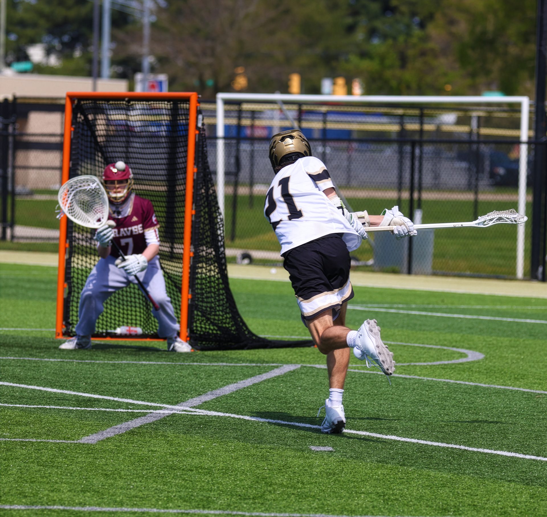 Man playing lacrosse on field.