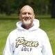 Man in white sweatshirt posing for picture on golf course.