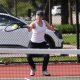 Woman playing tennis on court.