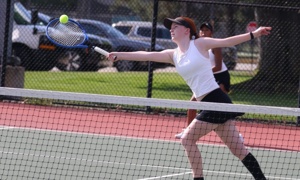 Female tennis player in action on court.